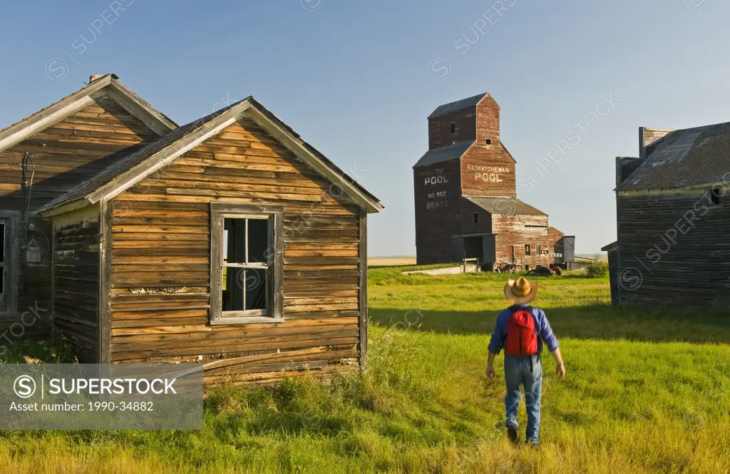 a man hikes through the abandoned town of Bents, Saskatchewan, Canada