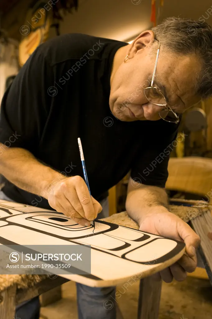 Kwa_Kiulth, North West Coast Artist, Calvin Hunt traces outlines on to a paddle for a commission at his Copper Maker studio in Fort Rupert. Fort Ruper...