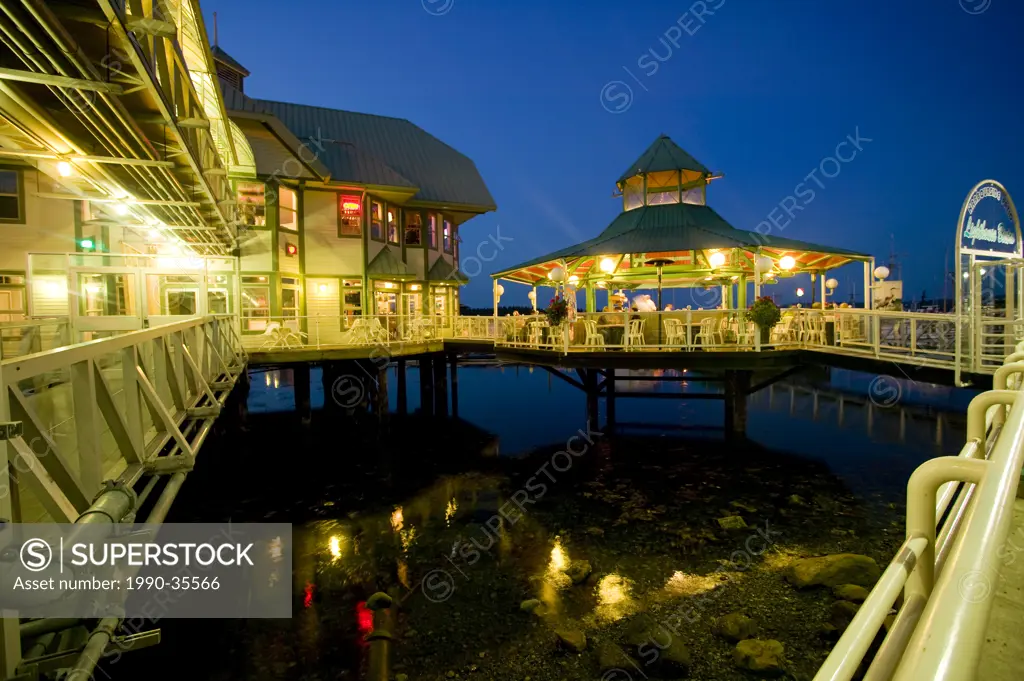 Waterside dining after dark emerges as the last vestiges of daylight slowly transform to dark along Nanaimo´s Waterfront Park. Nanaimo, Vancouver Isla...