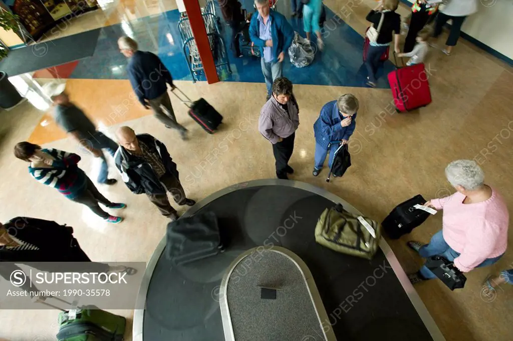 Passengers arriving at the Comox Airport YQQ await their baggage on one of the carousels located in the terminal. Comox, The Comox Valley, Vancouver I...
