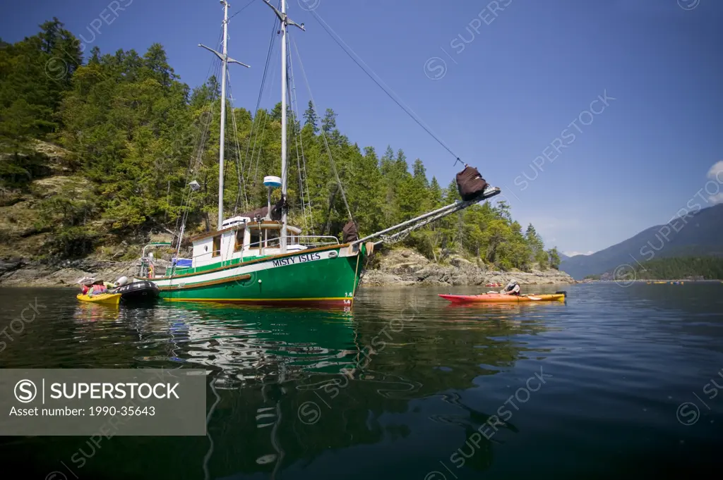 Kayakers launch from ´Misty Isles´, a 43 ft gaff rigged Schooner, in Desolation Sound Canada.Vancouver Island, British Columbia, Canada.