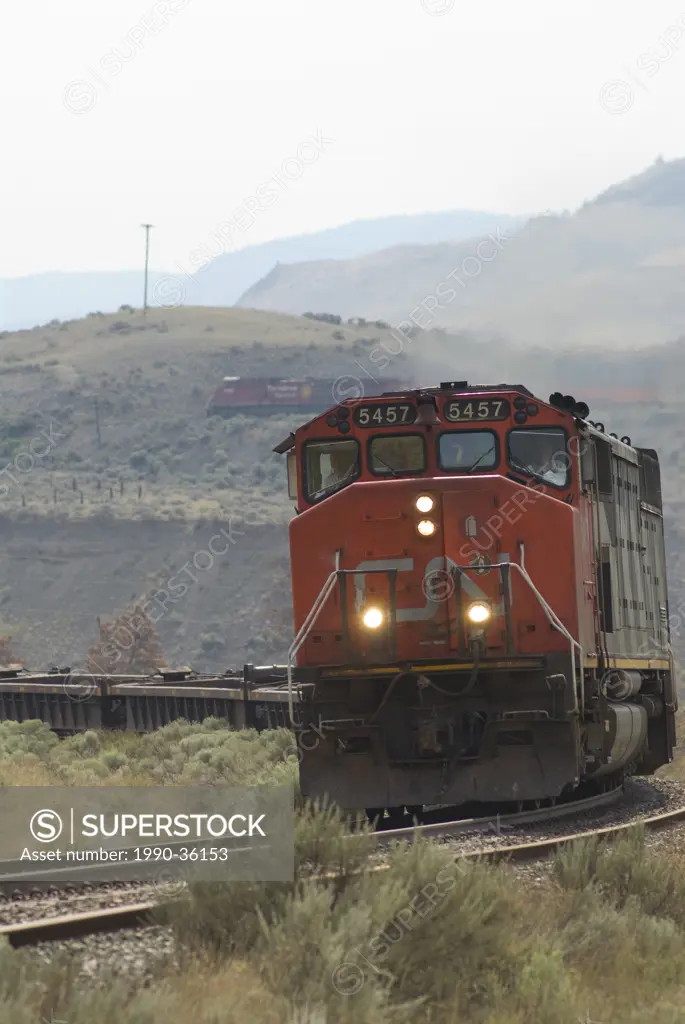 CN freight train near Ashcroft, BC passes by Juniper Beach campground, while a Canadian Pacific freight train passes in the background.