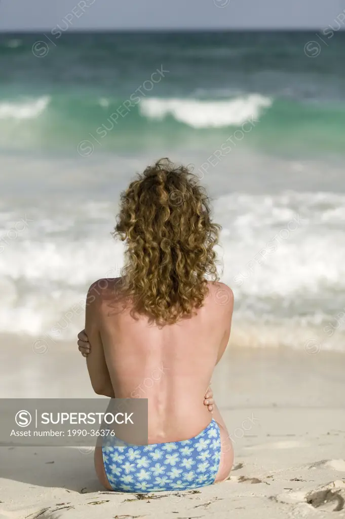 32 year old caucasian, blond woman on a swing, on a terrace of a hut on the coast,Tulum, Yucatan, Mexico