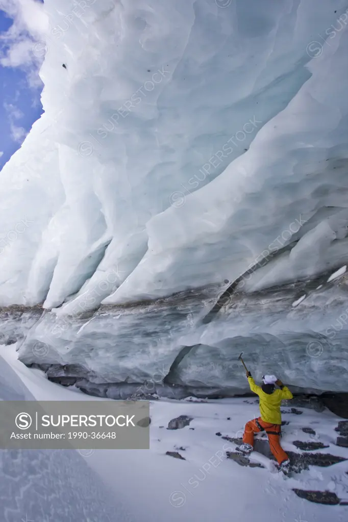 A young man explores an ice cave in Mount Assiniboine, Mount Assiniboine Provincial Park, British Columbia, Canada