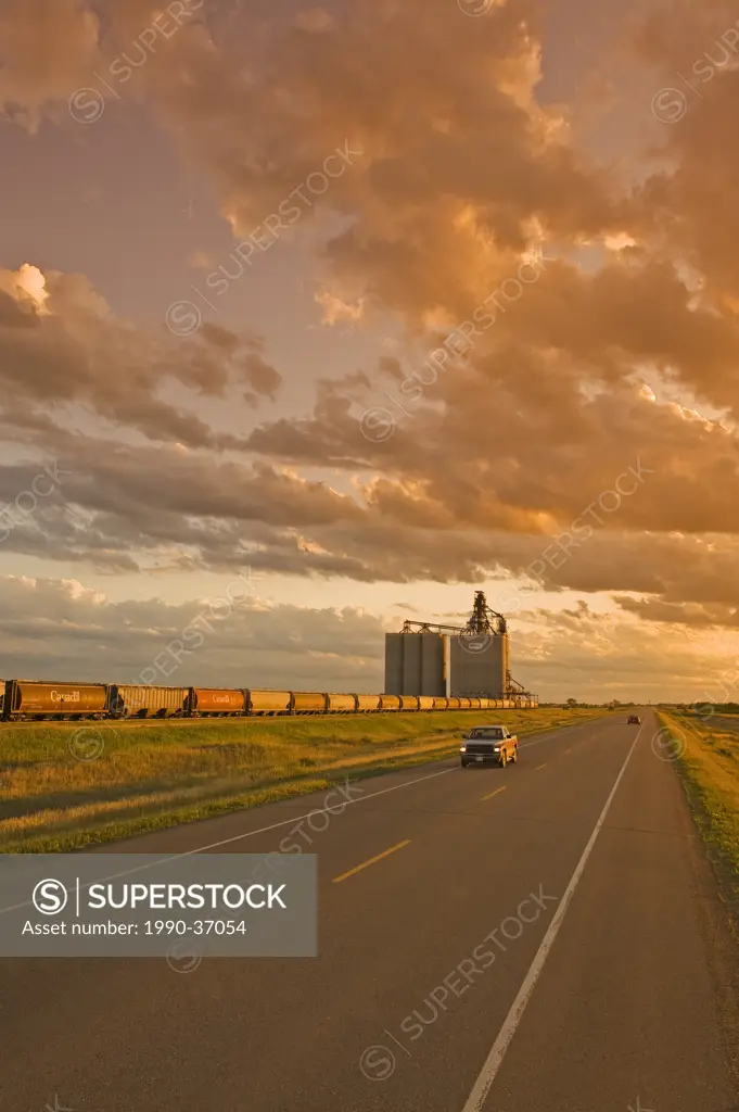 road going across the prairies and inland grain terminal in the background, near Estevan, Saskatchewan, Canada
