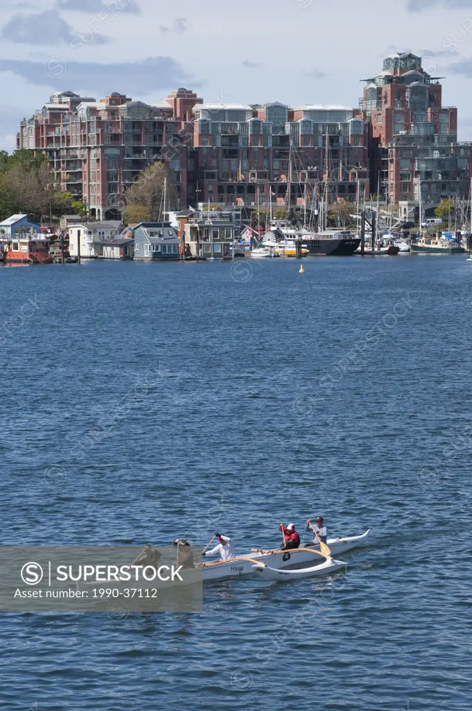 View to Fisherman wharf with floathomes and paddlers across Victoria Harbour, British Columbia, Canada