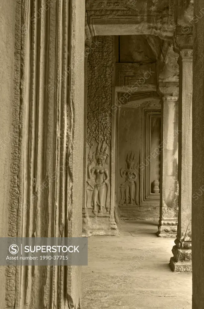 Apsara dancer bas reliefs stand in an intricately carved doorway at Angkor Wat at the Temples of Angkor near Siem Reap, Cambodia.