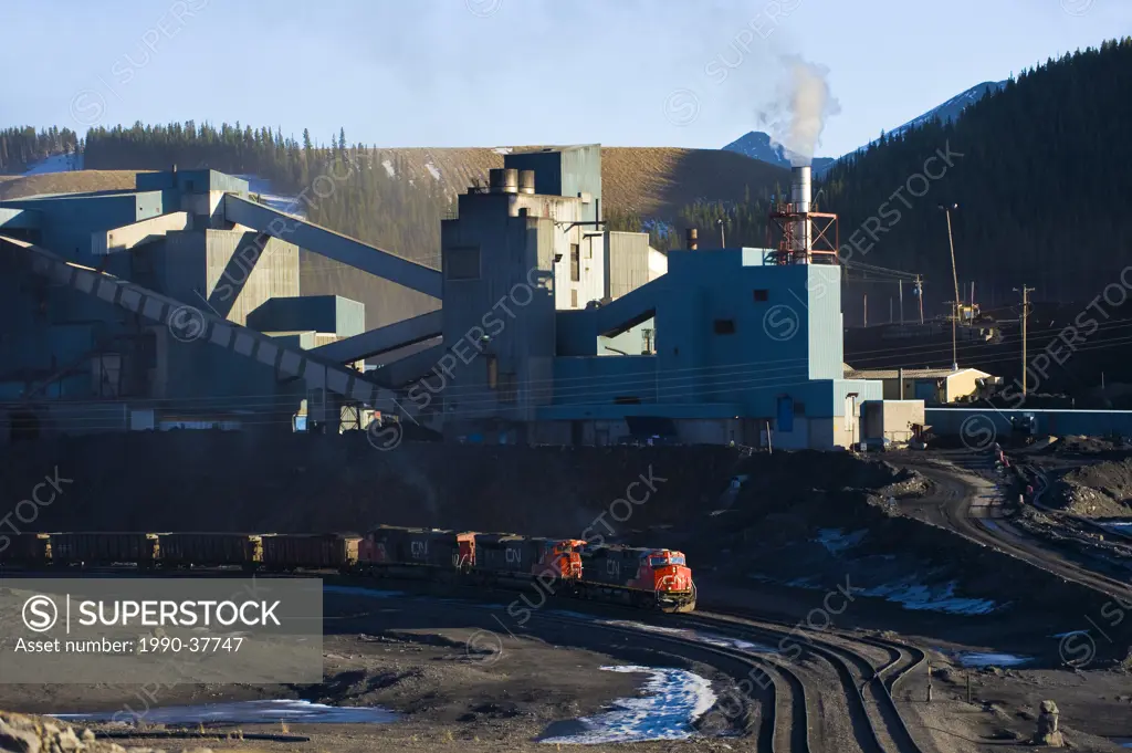 A working coal plant and a train being loaded with coal in the Alberta foothills, Canada.