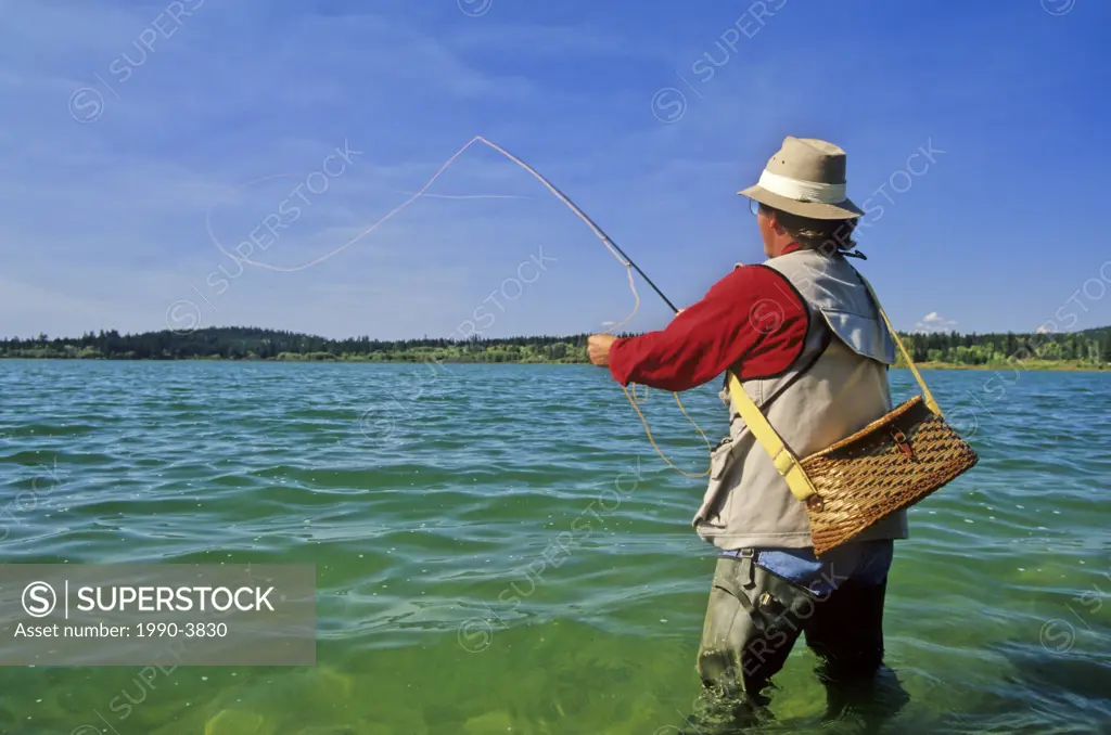 Angler fly fishing on 108 Mile Lake, British Columbia, Canada
