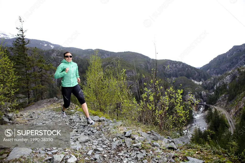 Woman trail running near the Cheakamus River in the Squamish_Whistler region, British Columbia, Canada.