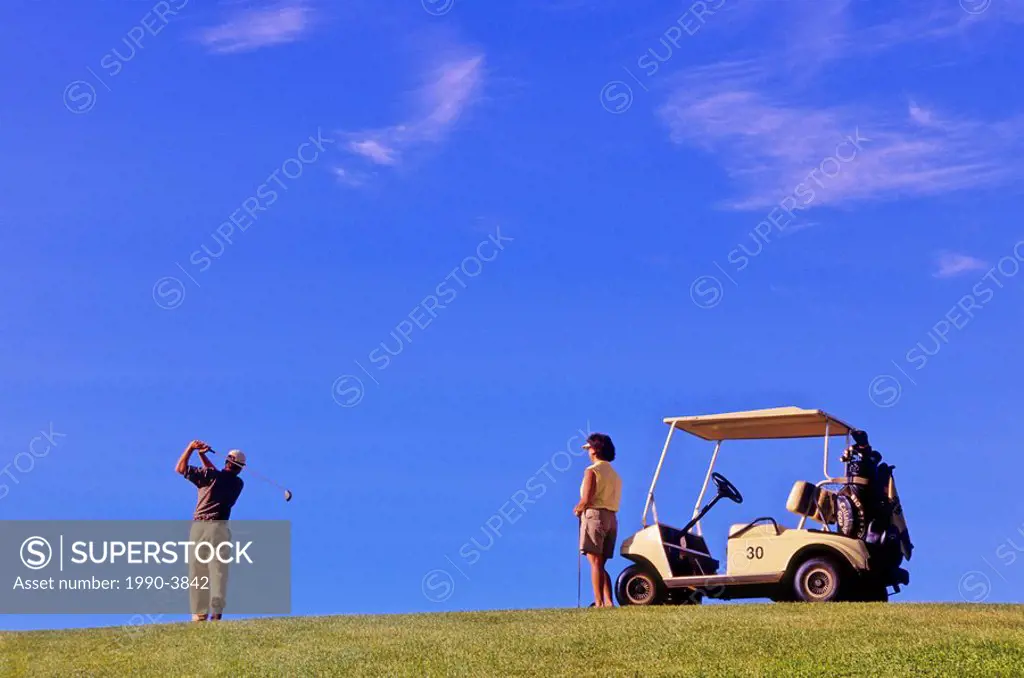 Golfers playing at 108 Mile Ranch golf course in the Cariboo region of British Columbia, Canada