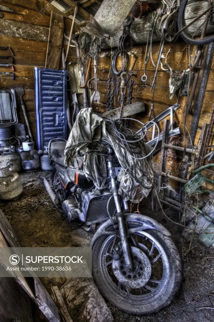 Close up of a dusty motorcycle in a storage barn.
