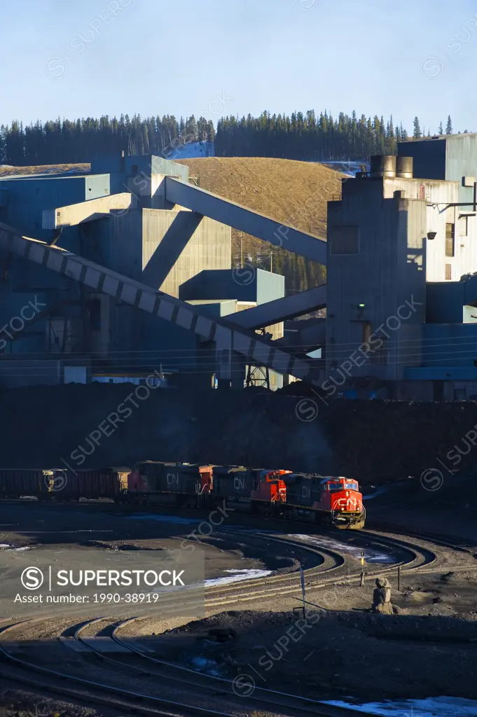 A working coal plant and a train being loaded with coal in the Alberta foothills, Canada.