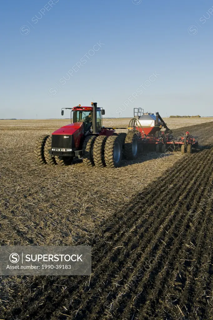 moving tractor and and air till seeder planting grain, near Dugald, Manitoba, Canada