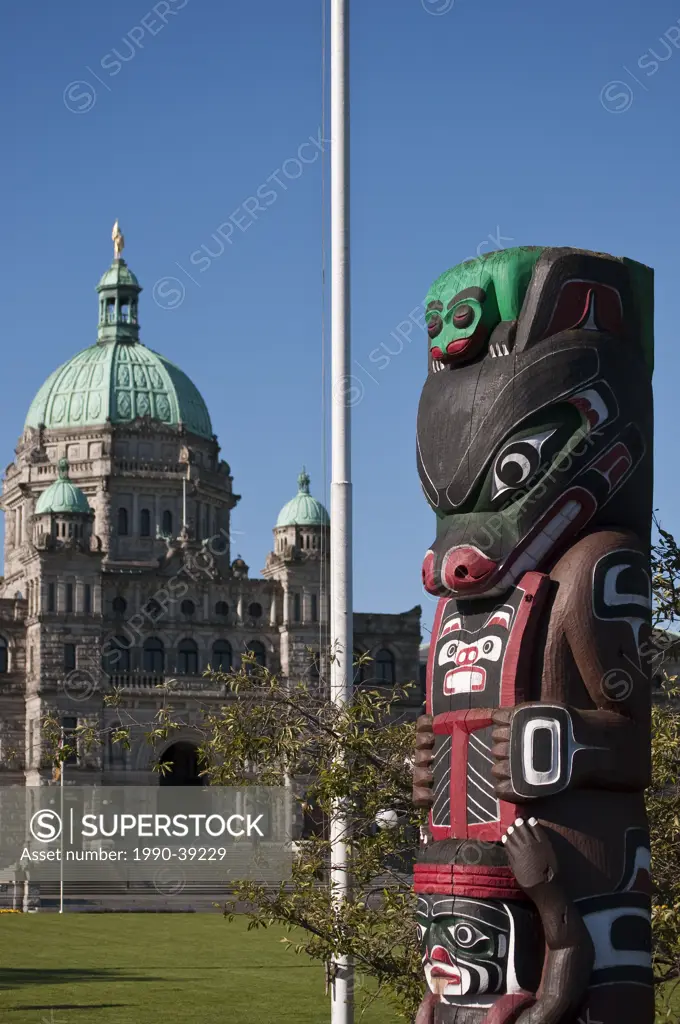 Totem pole and BC provincial legislative buildings, Victoria, British Columbia, Canada
