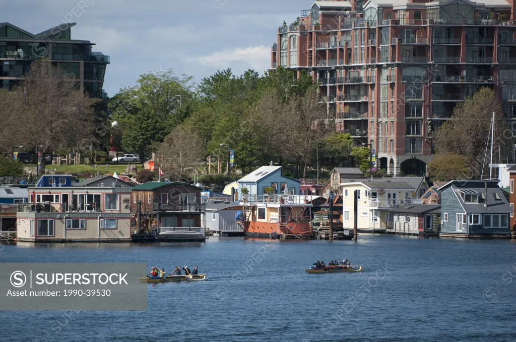 View to Fisherman´s wharf with floathomes and paddlers across Victoria Harbour, British Columbia, Canada