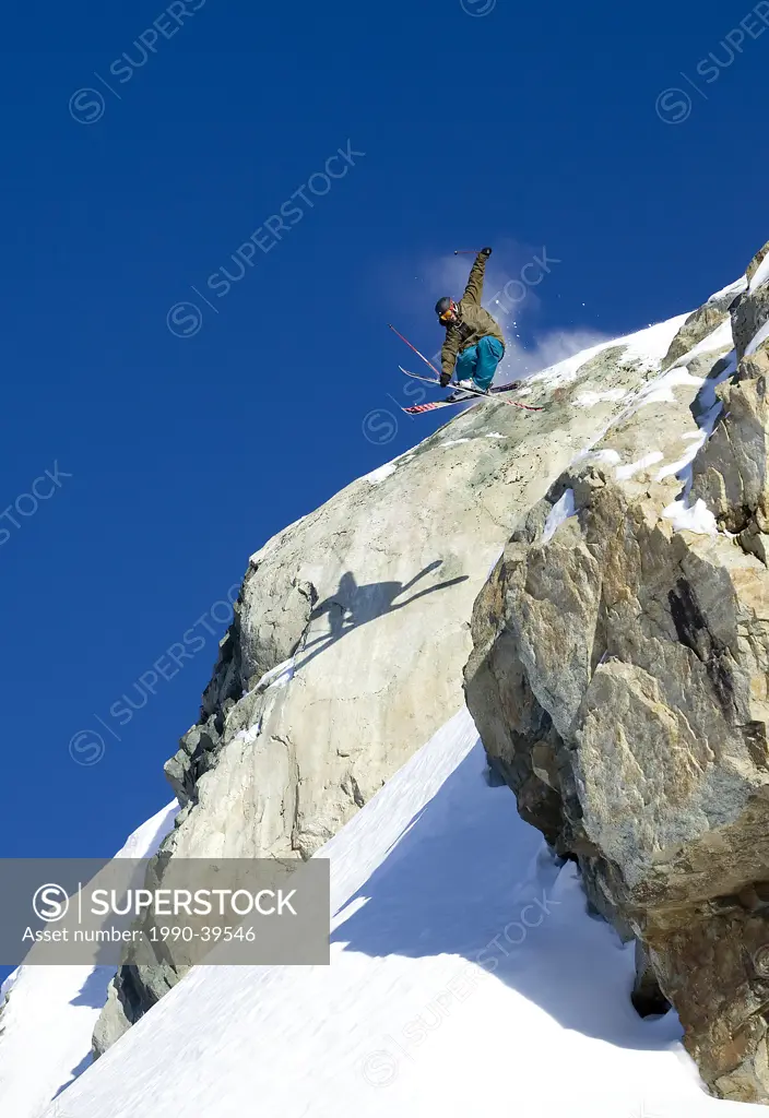 Man skiing over a rock cliff on Brandywine Mountain, Coast Mountains, British Columbia, Canada.