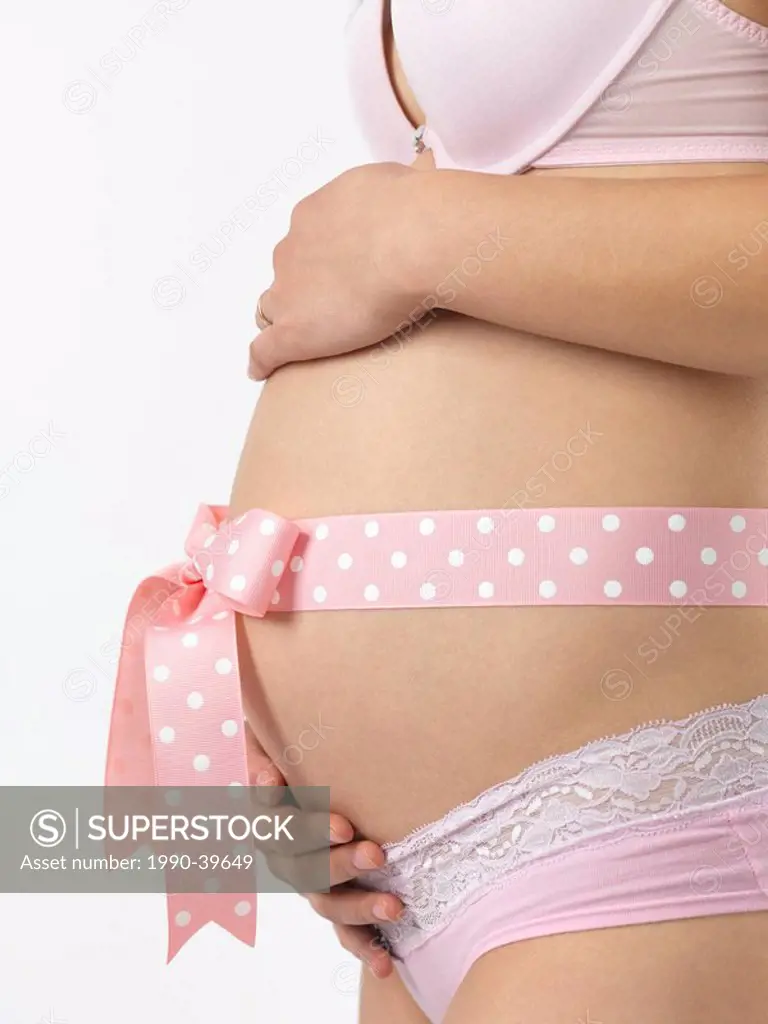 Pregnant woman with a pink bow on her belly