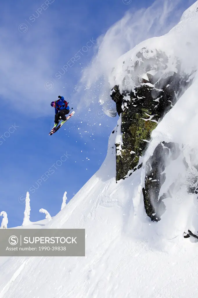 Man skiing over a rock cliff in the Whistler backcountry, Coast Mountains, British Columbia, Canada.