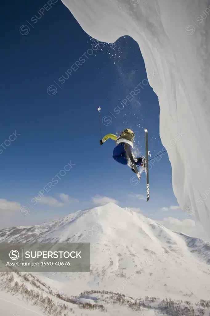 A skier flys off a cornice with Mt Annupuri in the background, Niseko Backcountry, Hokkaido, Japan