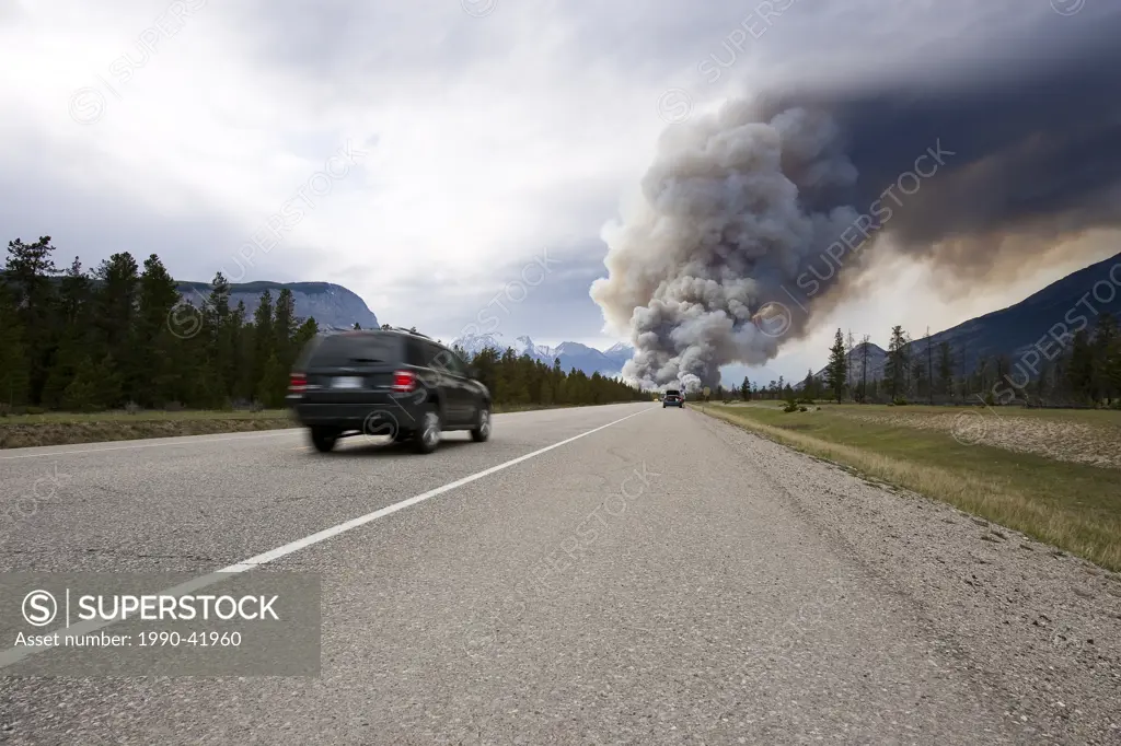 Forest fire visible from highway road in Jasper National Park, Canada