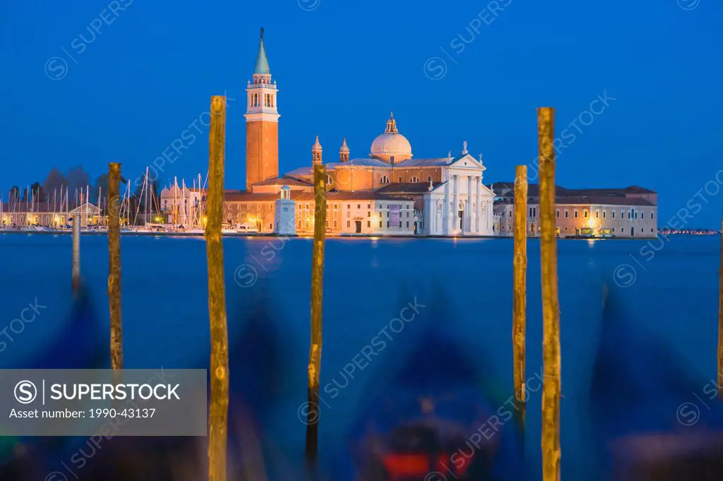 Gondolas with the church of Saint George Major in the distance at night, Venice, Italy