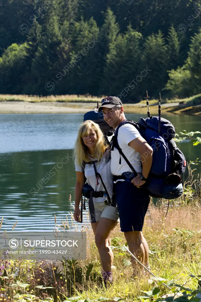 A middle aged couple prepares to take on the West Coast Trail from its southerly departure point near Port Renfrew. Port Renfrew, Southern Vancouver I...