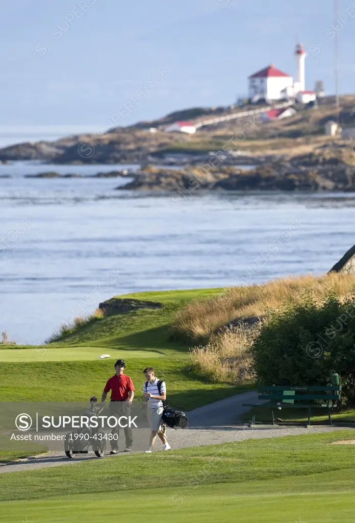 Two Young golfers comparing notes, stroll to the next hole on Oak Bay´s century old, Victoria Golf Club in Oak Bay. Victoria, Vancouver Island, Britis...
