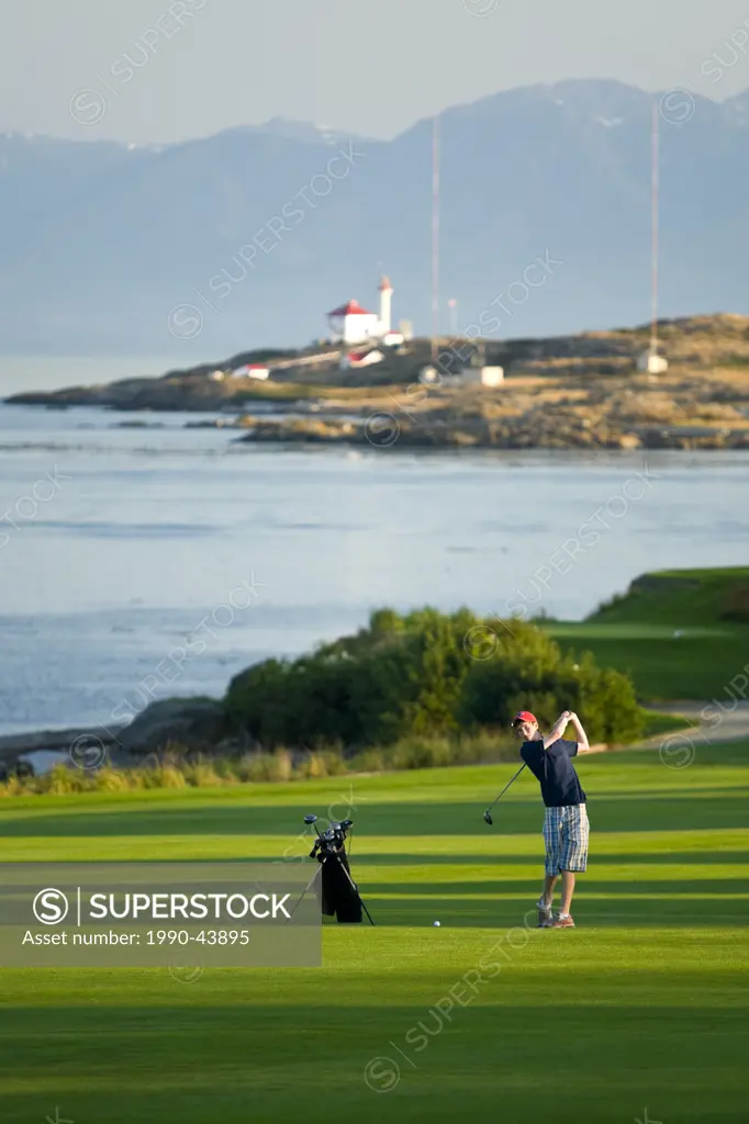 A young golfer takes a practice swing from the 3 fairway while golfing at the Royal Victoria Gulf Club. Victoria, Southern Vancouver Island, British C...