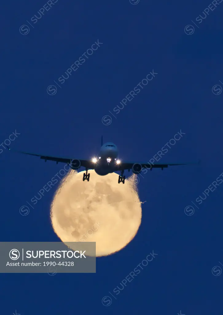 Airbus 330 passing above the full moon on approach to Vancouver International Airport. A high pressure wing tip vortex is visible bisecting the moon.