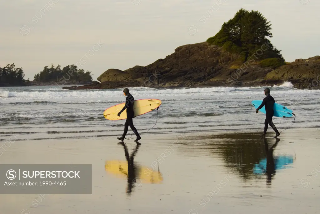 Surfers head into the chilly waters of Cox Bay, near Tofino, on the west coast of Vancouver Island, British Columbia, Canada