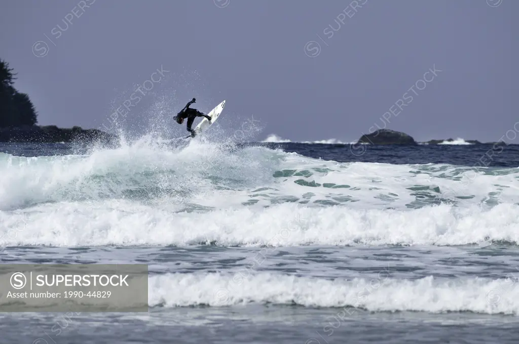 Surfer getting air on the crest of a wave at Chesterman Beach, Tofino, British Columbia, Canada.