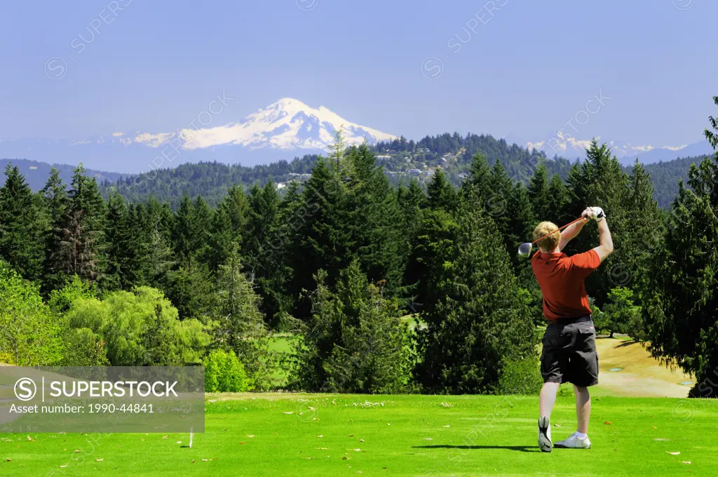 Cam Braes model release follows through after striking a golf ball at the first tee at the Arbutus Ridge Golf Club in Cobble Hill, BC. Mt. Baker in Wa...