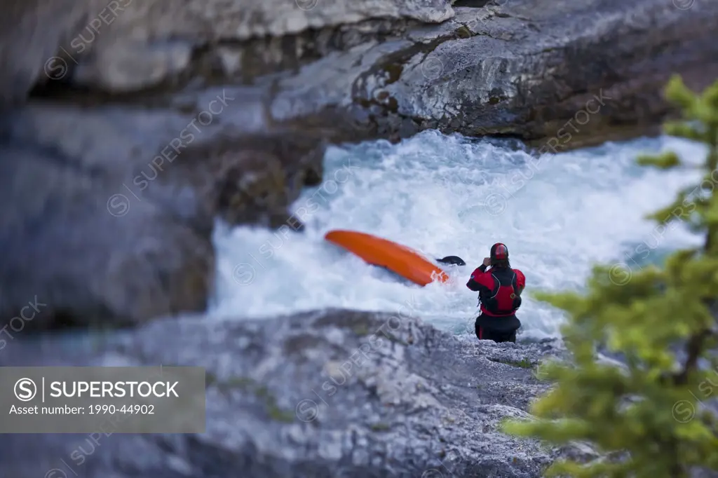 A male whitewater kayaker creekboating on the Elbow River, Alberta, Canada