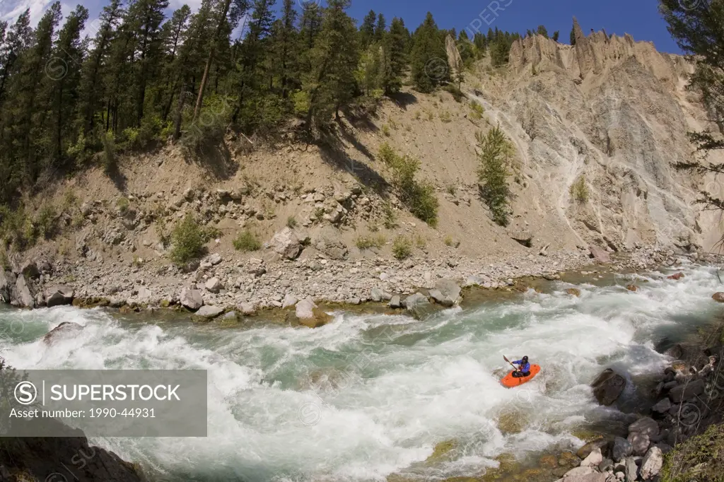 A male kayaker paddles the Wigwam River, class 4 in Fernie, British Columbia, Canada