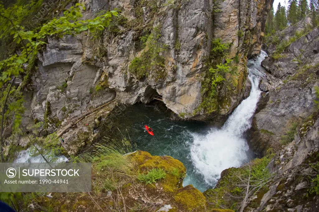 A male kayakers drops a 30 ft waterfall on Sand Creek, Galloway, British Columbia, Canada
