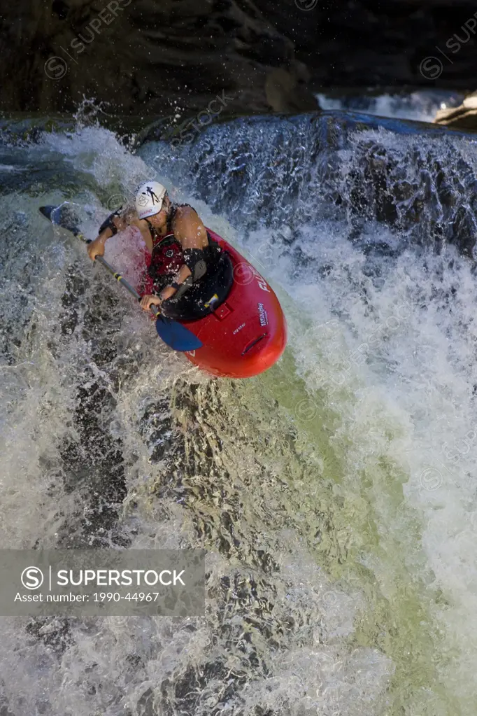 A male kayaker paddles off Raft Falls, Clearwater, British Columbia, Canada
