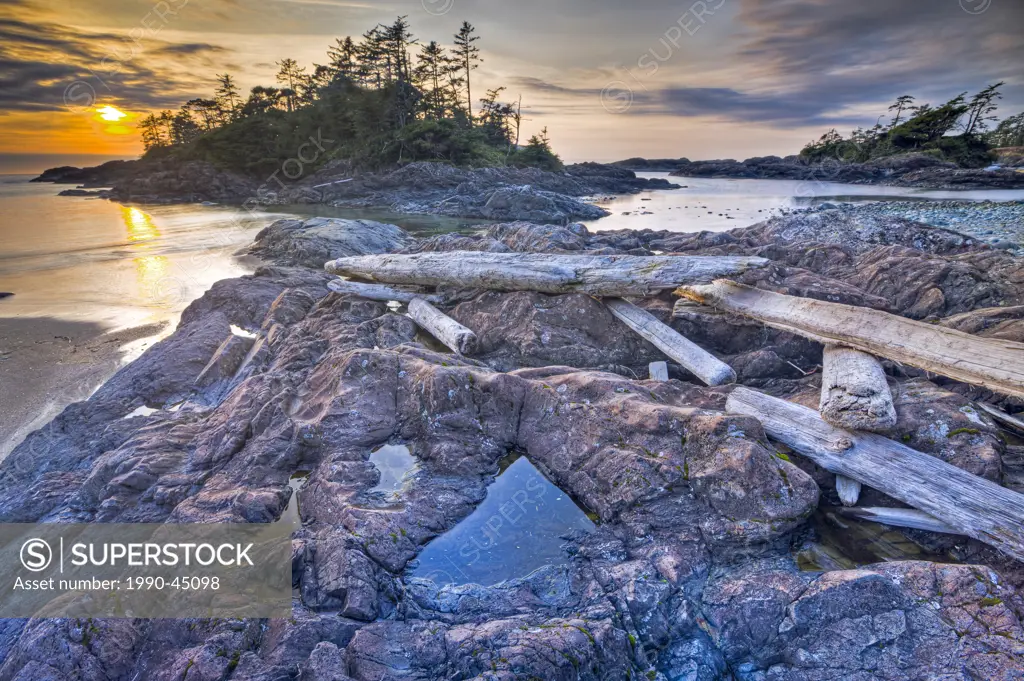Driftwood strewn over a rocky outcrop along South Beach at sunset, Pacific Rim National Park, Long Beach Unit, Clayoquot Sound UNESCO Biosphere Reserv...