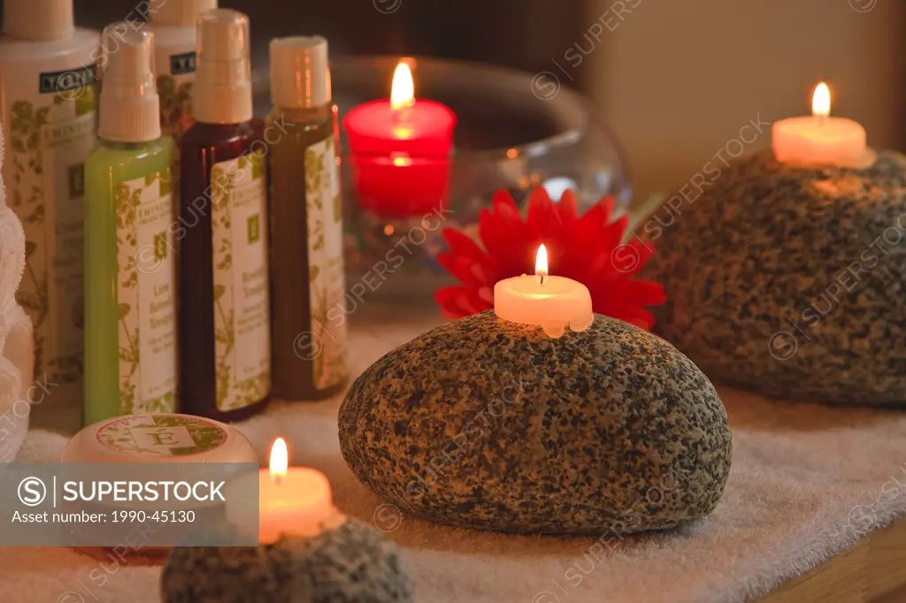 Candles on large west coast rocks with bottles of beauty products at the Black Bear Resort & Spa in Port McNeill, Northern Vancouver Island, British C...