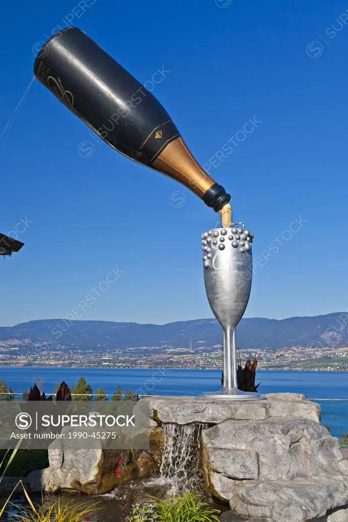 Large bottle of sparkling wine and goblet in the Summerhill World Peace Park at the Summerhill Pyramid Winery, a certified organic vineyard, Kelowna, ...