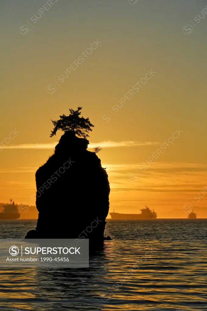Sunset silhouettes Siwash Rock, the seawall, Stanley Park, Vancouver, British Columbia Canada