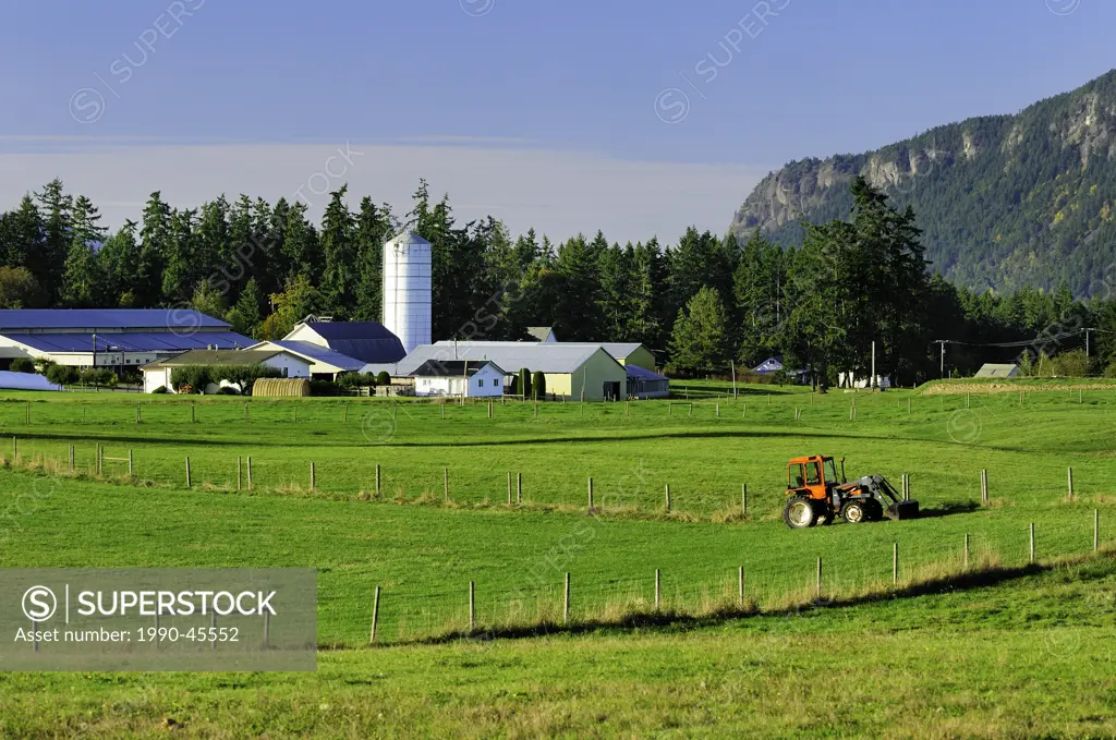 A tractor sits in a field near a farm in Cowichan Bay, British Columbia, Canada.