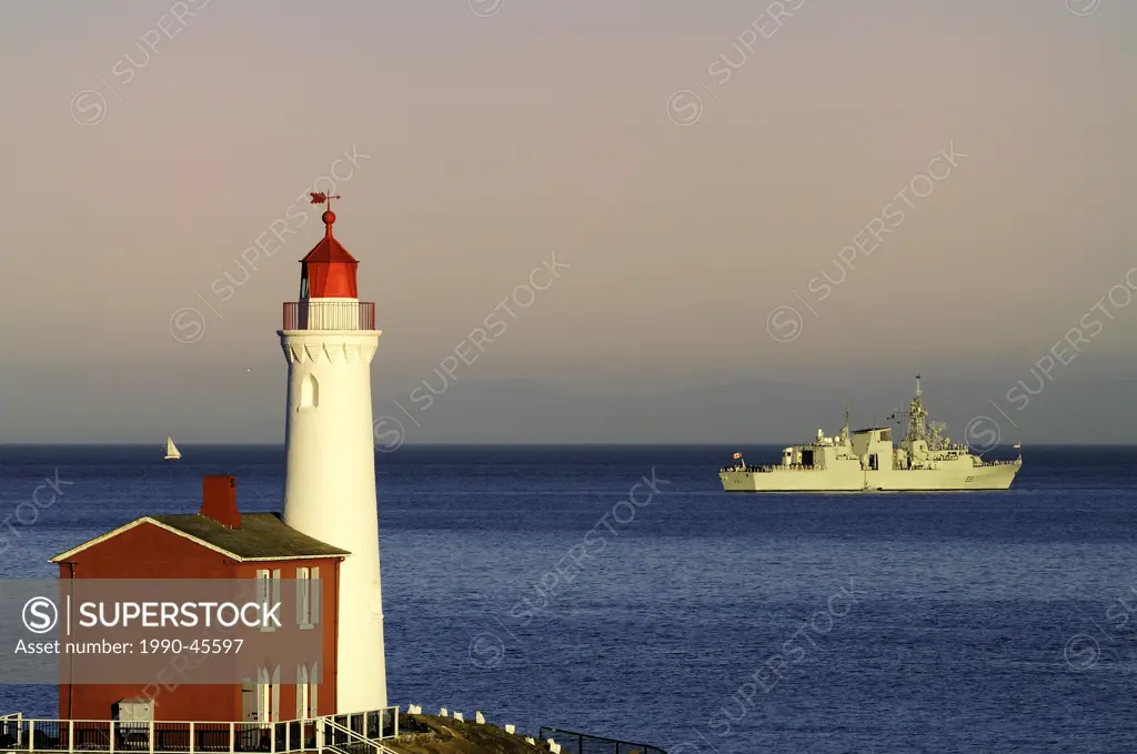 The HMCS Vancouver and a lone sailboat off Fort Rodd Hill and the Fisgard Lighthouse during the Canadian Navy´s 100 year celebration near Victoria, Br...