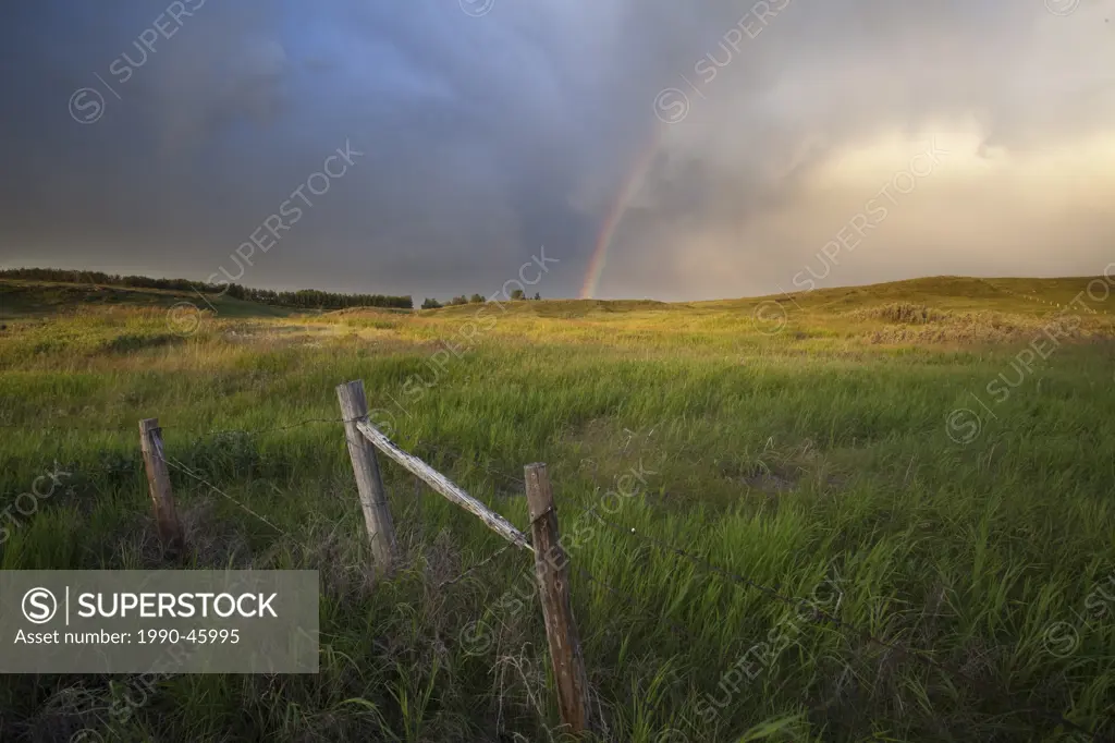 Rainbow and passing storm North of Calgary, Alberta, Canada.
