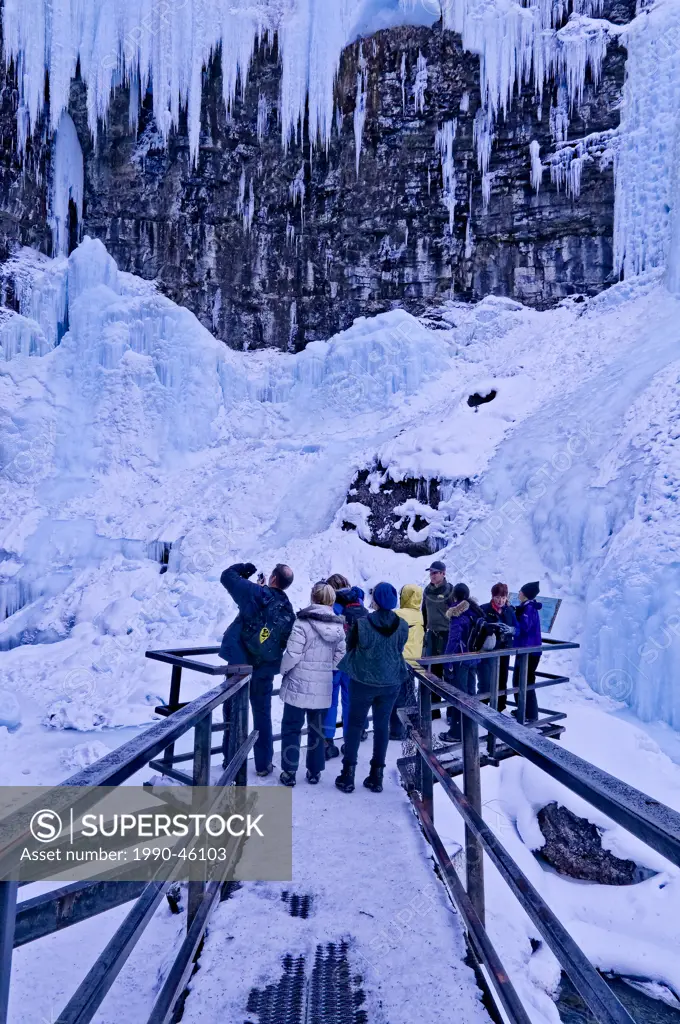 Interpretive tour group at frozen Upper Falls, Johnston Canyon, Banff National Park, Alberta, Canada
