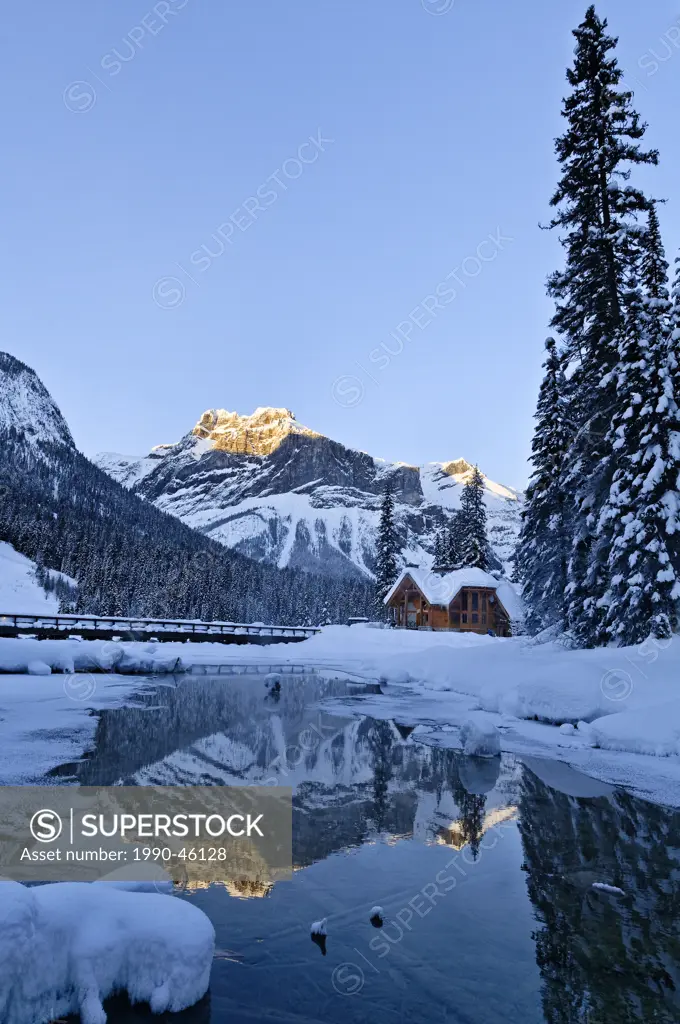 Restaurant of Emerald Lake Lodge complex, reflected in outlet stream at Emerald Lake, Winter, Yoho National Park, British Columbia, Canada