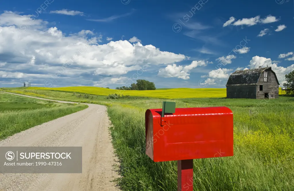 Mailbox along country road with old barn in the background, near Somerset, Manitoba, Canada,