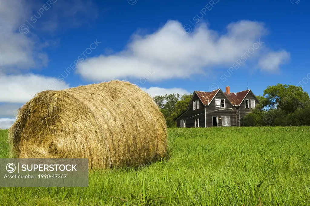 Hay bale and old house, near Notre Dame de Lourdes, Manitoba, Canada
