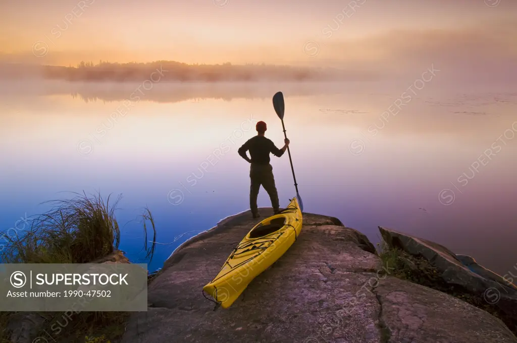 Man with kayak,Bunny Lake, near Sioux Narrows, Northwestern Ontario, Canada