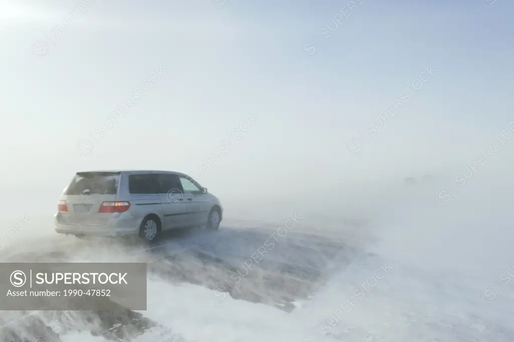 Van on road covered with blowing snow, near Morris, Manitoba, Canada